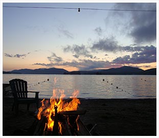 campfire by a lake at dusk